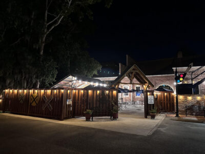 Lit outdoor restaurant patio entrance at night.